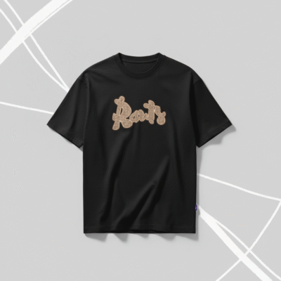 A black short-sleeved t-shirt featuring a stylized 'Roots' logo on the chest, rendered in a light brown burlap-like texture. The t-shirt is displayed on a clean grey background.